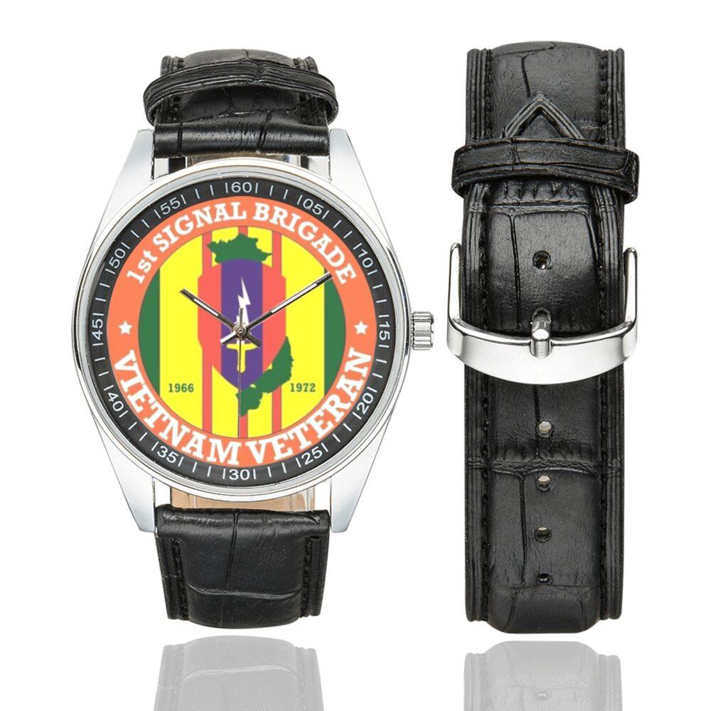 Men's casual watch with a round dial featuring the US Army 1st Signal Brigade Vietnam Veteran emblem, silver-tone case and black leather strap, shown with the strap to the side.