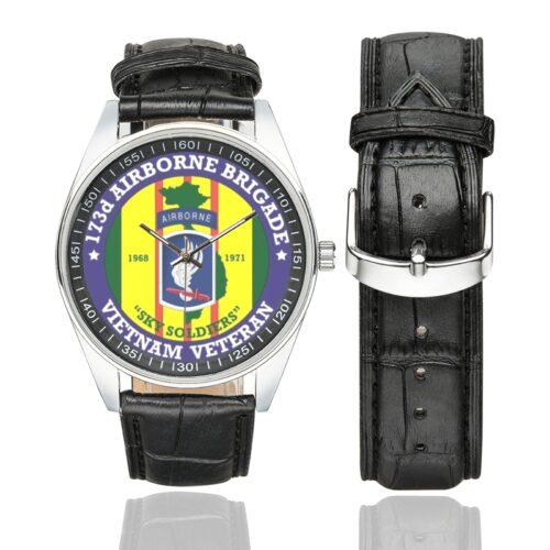 Men's casual watch with a round dial featuring the US Army 173 Airborne BBDE Vietnam emblem, silver-tone case and black leather strap, shown with the strap to the side.