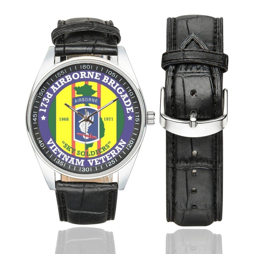 Men's casual watch with a round dial featuring the US Army 173 Airborne BBDE Vietnam emblem, silver-tone case and black leather strap, shown with the strap to the side.
