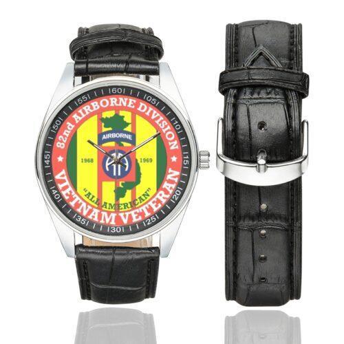 Men's casual watch with a round dial featuring the US Army 82nd Airborne Division Vietnam Veteran emblem, silver-tone case and black leather strap, shown with the strap to the side.