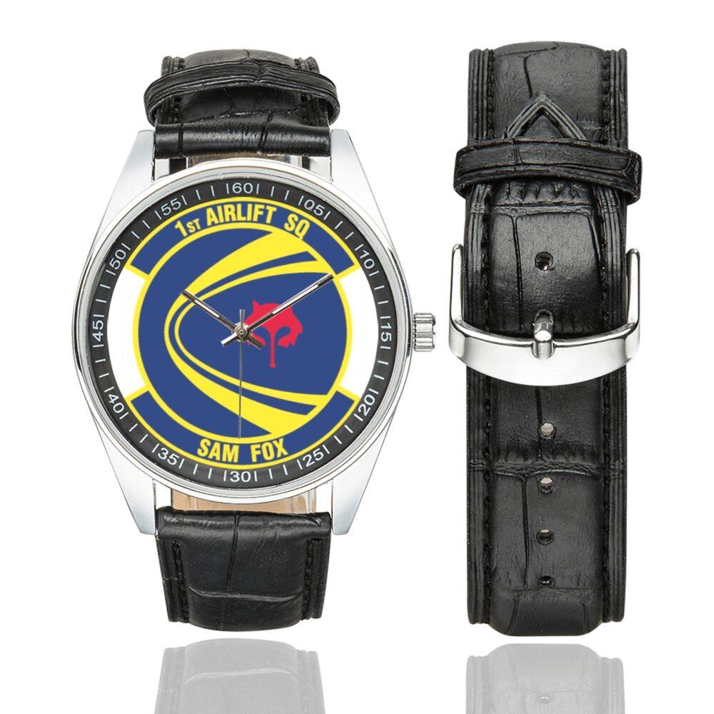 Men's casual watch with a round dial featuring the USAF 1st Airlift Squadron- emblem, silver-tone case and black leather strap, shown with the strap to the side.