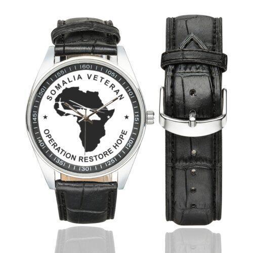 Men's casual watch with a round dial featuring the Somalia Veteran2 emblem, silver-tone case and black leather strap, shown with the strap to the side.