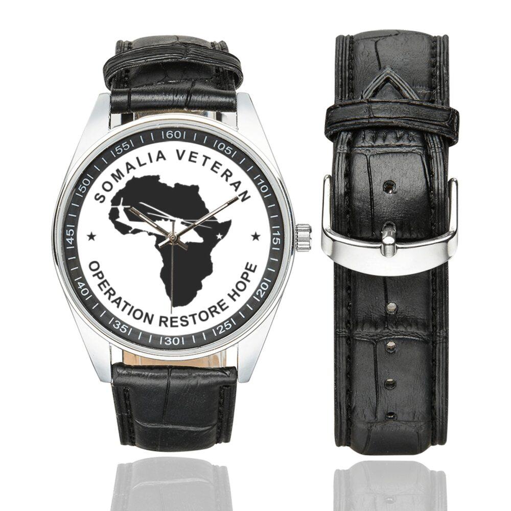 Men's casual watch with a round dial featuring the Somalia Veteran2 emblem, silver-tone case and black leather strap, shown with the strap to the side.