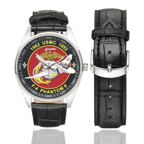 Men's casual watch with a round dial featuring the USMC F-4 Phantom emblem, silver-tone case and black leather strap, shown with the strap to the side.