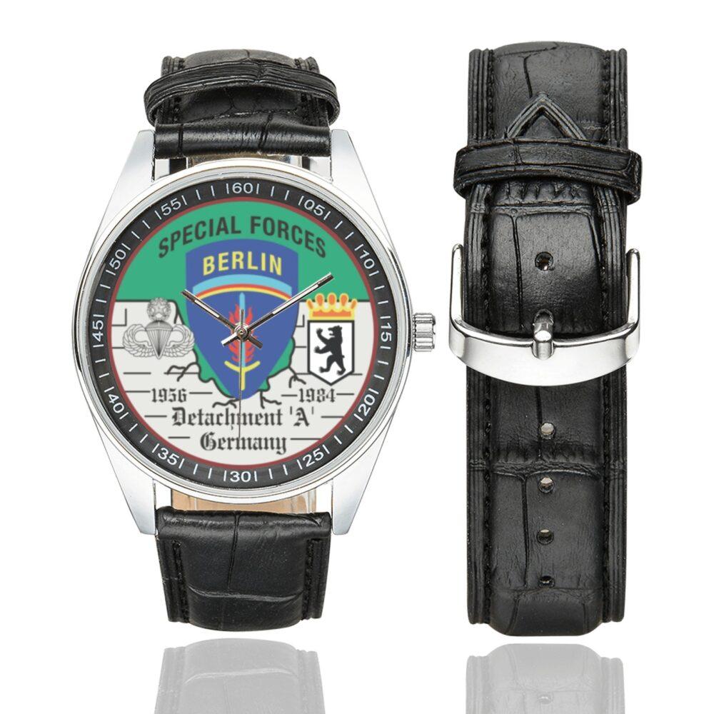 Men's casual watch with a round dial featuring the US Army Special Forces Detachment A Berlin Brigade emblem, silver-tone case and black leather strap, shown with the strap to the side.