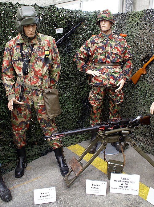 Swiss Army Museum display: a tank corporal in the 1973 tank jumpsuit, an infantry private in the Model 70 battle suit, and a 7.5 mm MG 51 machine gun.