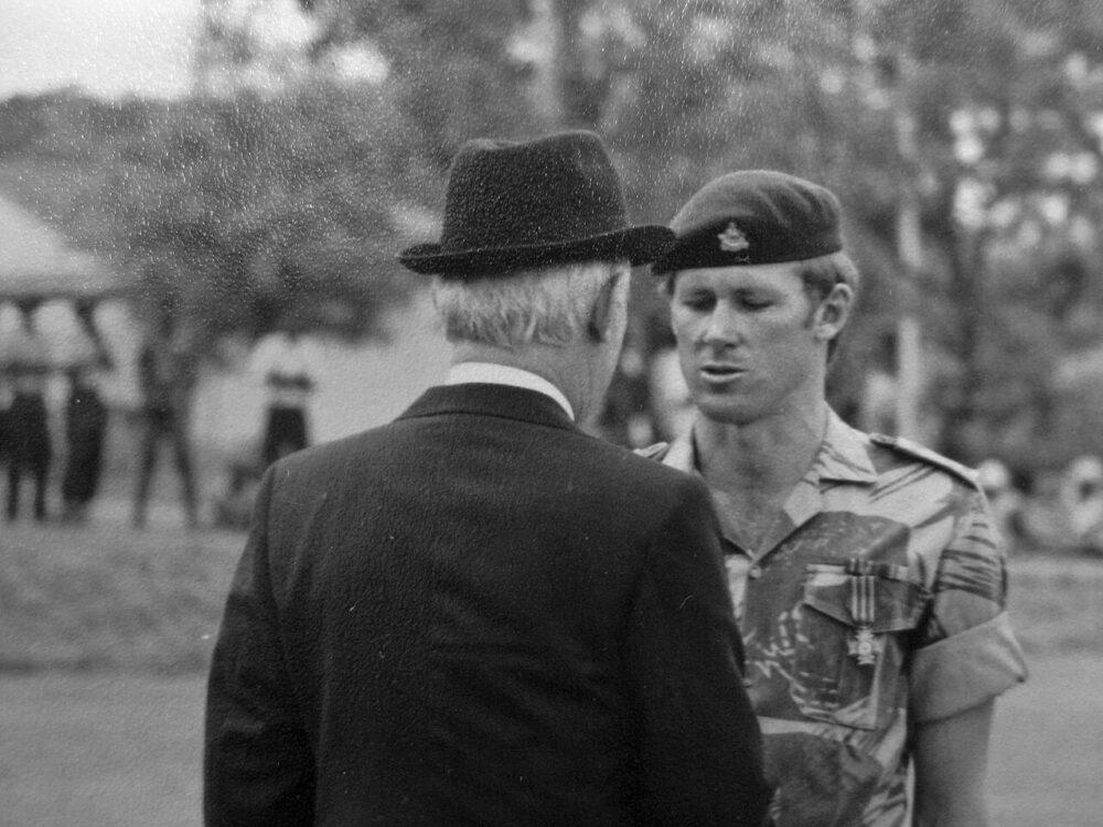 Acting Lieutenant Nigel Theron in Rhodesian Brushstroke shirt and RLI beret receiving the Bronze Cross of Rhodesia from President John Wrathall, 15 October 1976