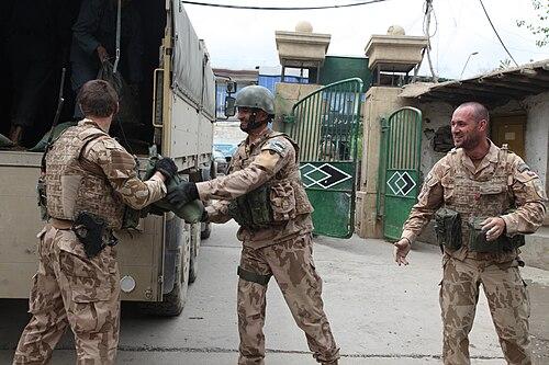 Czech soldiers wearing the vz.95 desert camouflage unloading sandbags with Afghan Uniformed Police at a checkpoint in Afghanistan (2014)