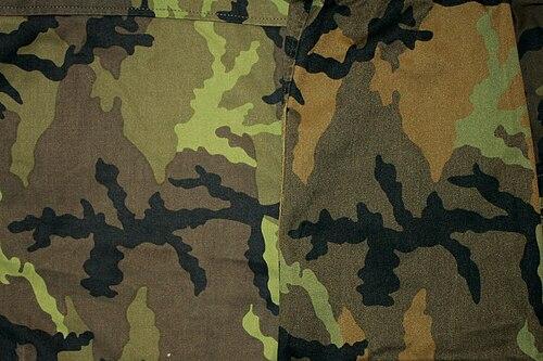Close-up of the Czech vz.95 forest camouflage showing two fabric colour variants — the 1995-2007 palette (left) and the 2013 standard palette (right) — with a clear green-to-brown colour shift.