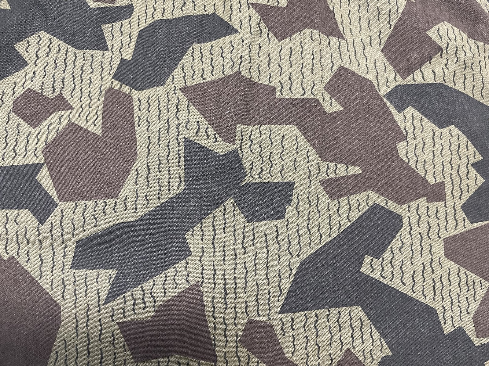 Close-up of the Bulgarian splinter camouflage print showing dark angular shapes and thin wavy streak lines on a light ground