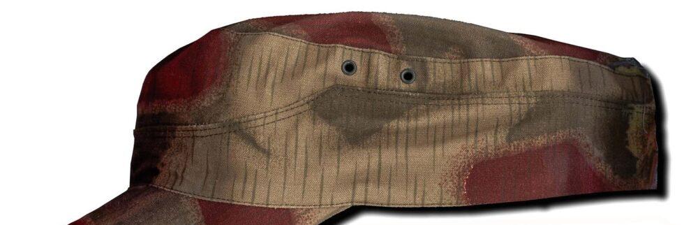 Bundesgrenzschutz field cap in Sumpfmuster 43 laid flat on a white background: a light beige ground with maroon and dark green shapes with hard edges, crossed by fine vertical rain streaks