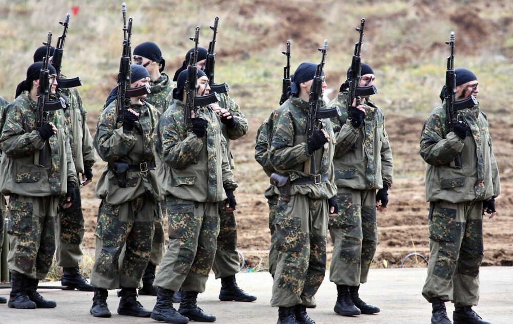 Russian internal troops special purpose unit servicemen in camouflage uniforms standing in line with assault rifles, Interpolitex 2010 exhibition, Moscow.