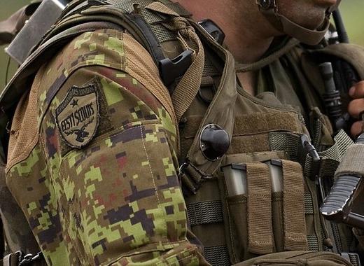 Close detail of the sleeve of an Estonian soldier's pixelated woodland camouflage jacket, with crisp square blocks in light green, olive, brown and very dark brown.