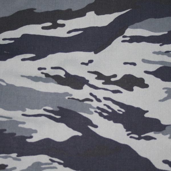 A square close-up of a camouflage print with large, roughly horizontal blotches in white-grey, mid grey and very dark blue-black.