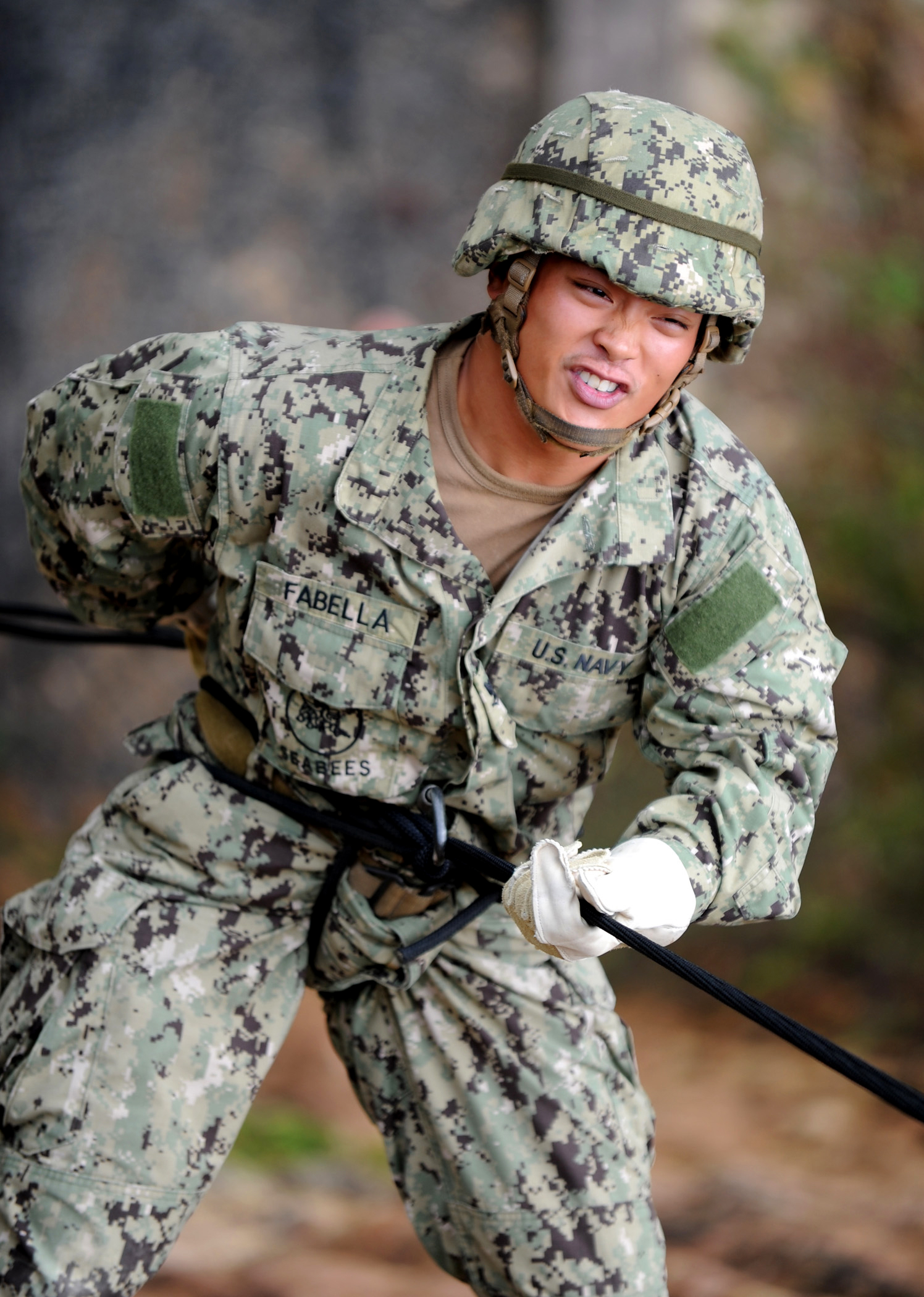 U.S. Navy Seabee in woodland digital camouflage rappelling at a jungle warfare training centre in 2013