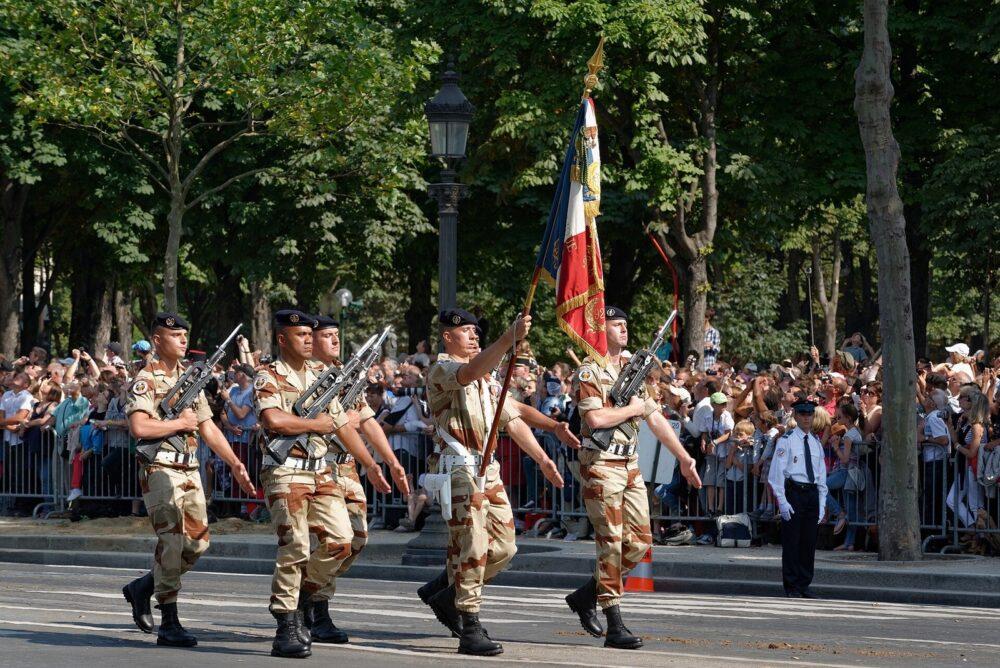 Colour guard of about five soldiers carrying a single unit flag during the Bastille Day 2013 parade in Paris