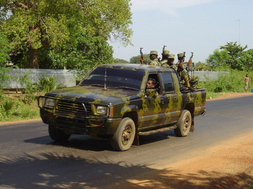 LTTE cadres travelling in the back of a pickup truck painted in broad ochre-olive strokes over dark green, near Killinochi, April 2004