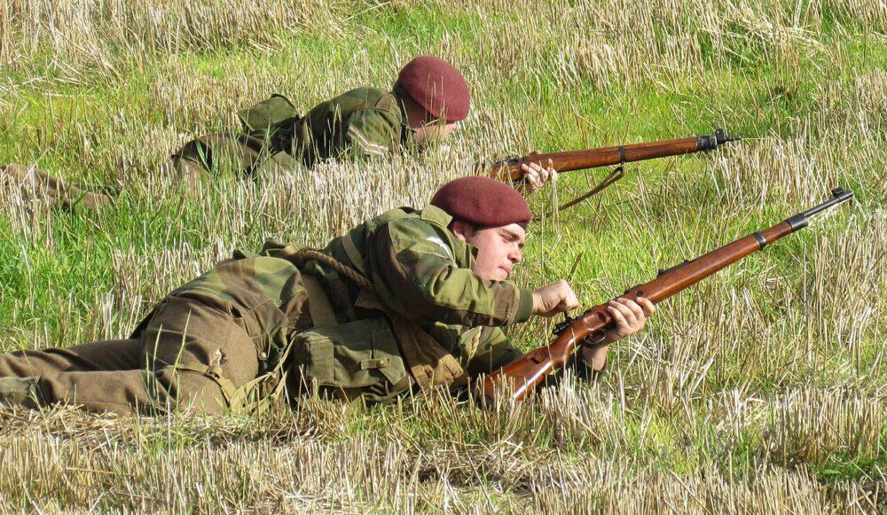 Re-enactors in Denison brushstroke camouflage smocks taking up a firing position