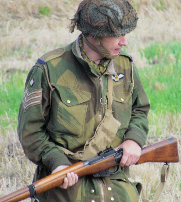 Reenactor wearing a Denison brushstroke camouflage smock, front view, green and brown strokes on khaki