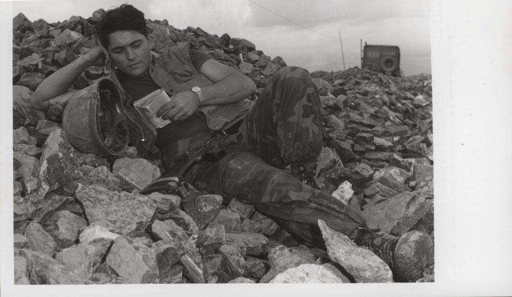 US Marine in ERDL camouflage resting on a pile of rocks in Vietnam, 1968