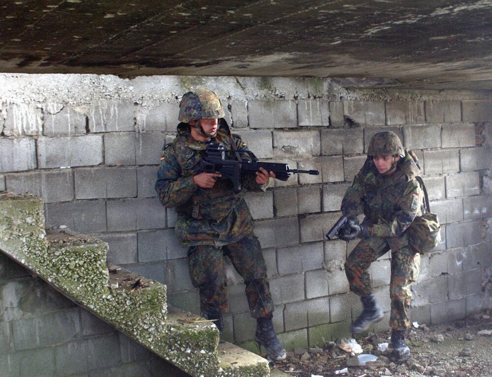 German Bundeswehr soldiers in Flecktarn camouflage moving through a doorway