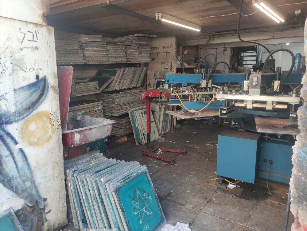A screen-printing workshop with printing screens and a printing press
