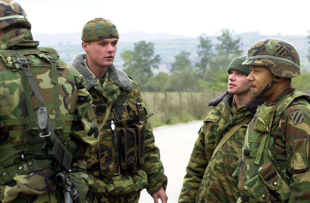 Russian soldiers in two different Russian three-colour drawings and United States soldiers at Checkpoint 75 in Kosovo, 2003