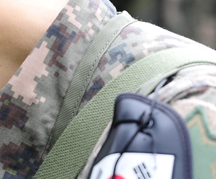 Close-up of the pixelated Republic of Korea Army camouflage fabric on the shoulder of a 6th Infantry Division soldier, showing square blocks in the pattern's five declared tones (conifer green, darker olive, tree-trunk brown, charcoal grey and pale sandy tan), August 2014