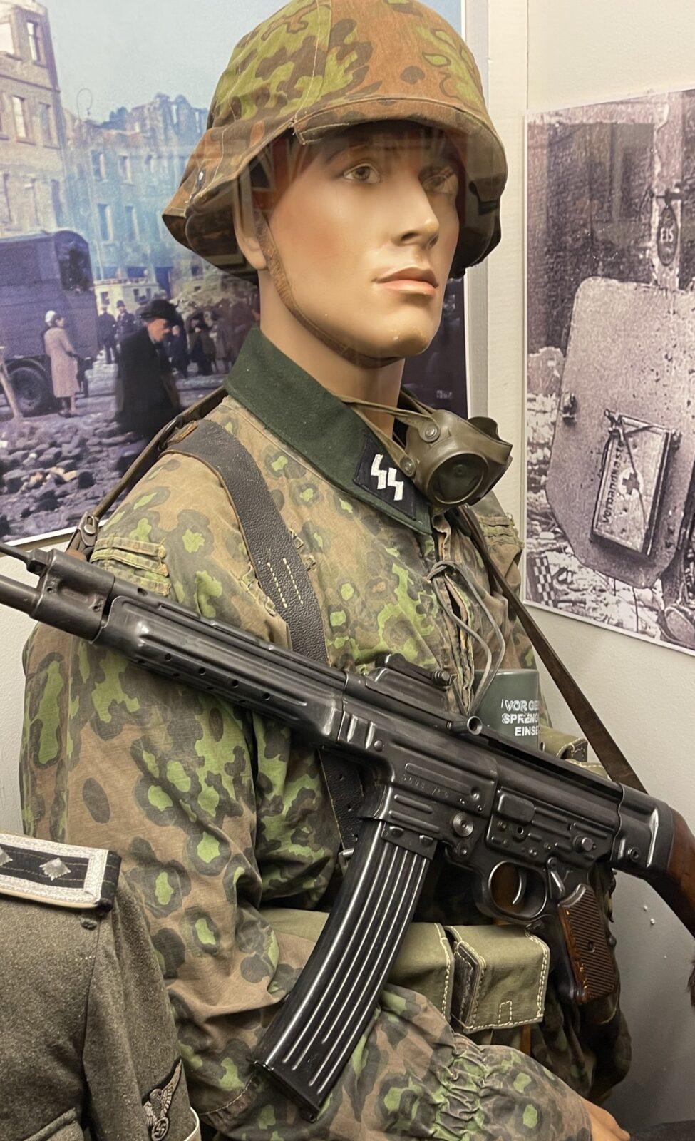 Museum display figure in a Waffen-SS camouflaged tunic with camouflaged helmet cover, StG 44 and gas-mask canister, Lofoten War Memorial Museum, Norway