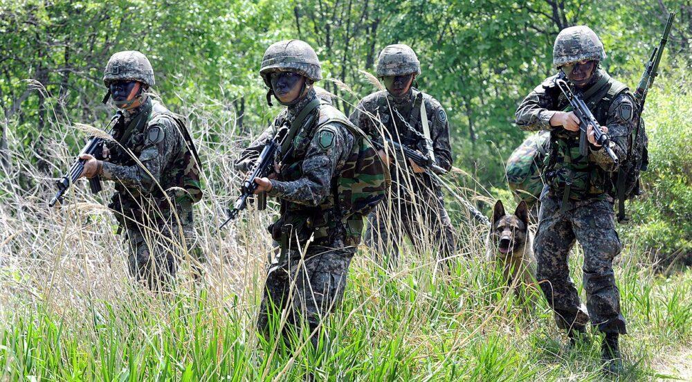Republic of Korea Army reconnaissance soldiers in digital granite camouflage crossing a hillside during training, Hwacheon, 2014