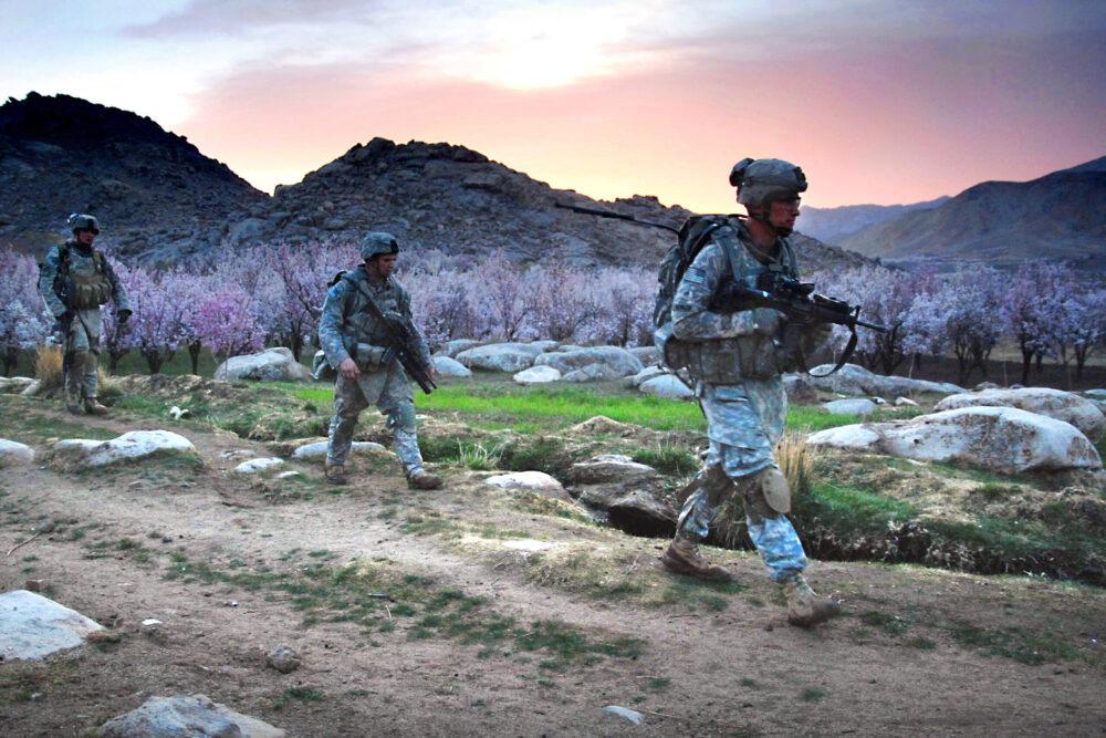 U.S. soldiers in UCP walking in single file at dawn near FOB Baylough, Zabul, Afghanistan, 2009
