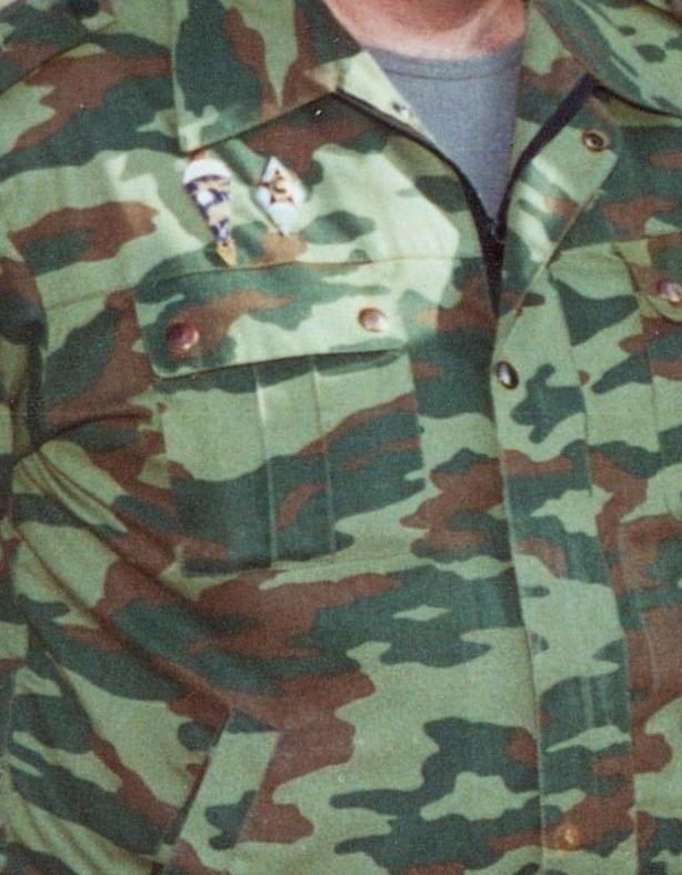 Close view of a Russian field uniform in banded green, brown and tan camouflage, showing elongated pale bands running horizontally across a darker green ground