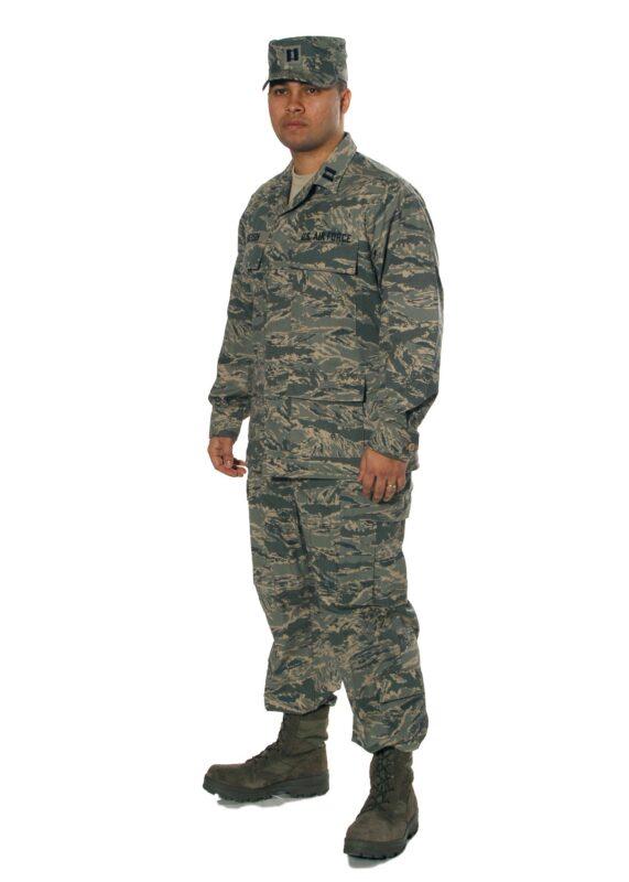 Airman Battle Uniform shown on a display form: coat with U.S. Air Force and name tapes, ABU patrol cap, and trousers bloused over sage green boots, in the Air Force's digitised tiger stripe pattern.
