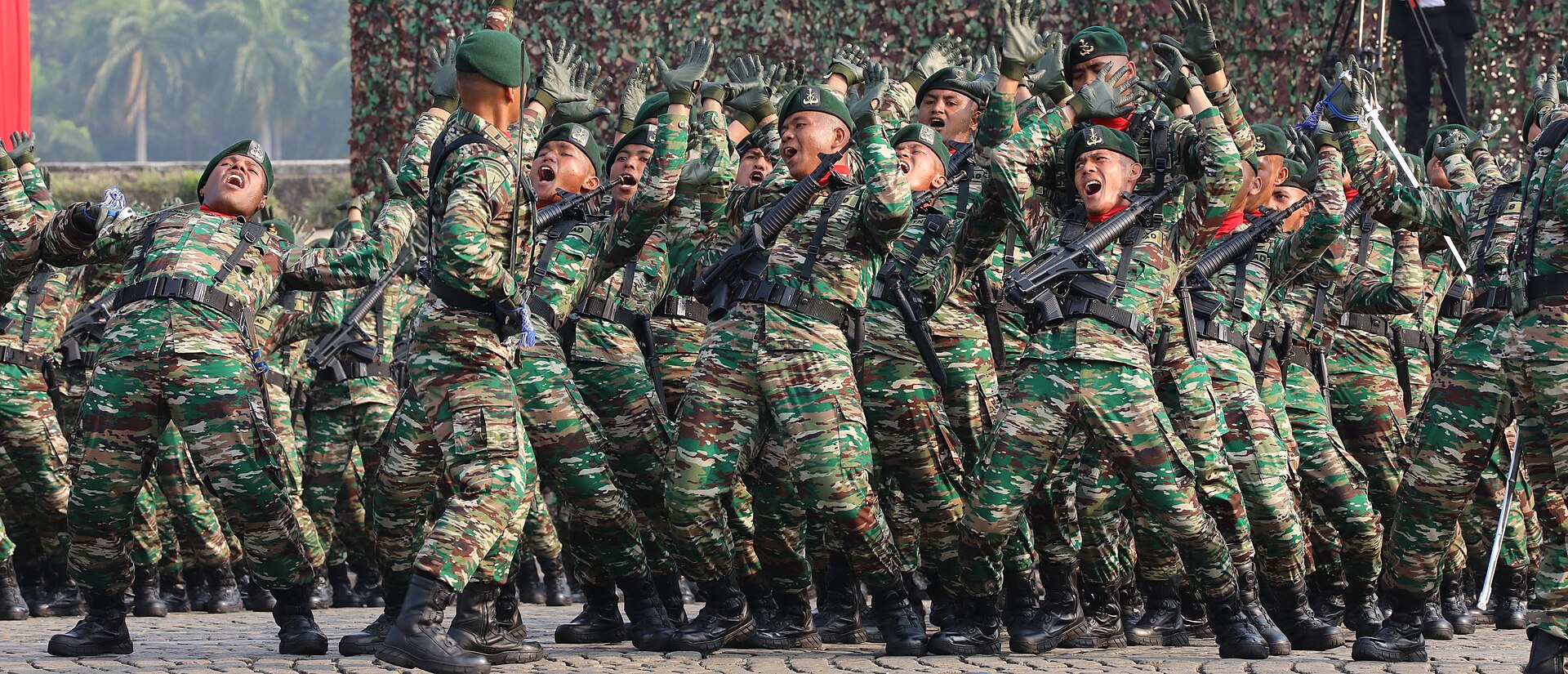 Indonesian Army troops in the PDL Khas Matra Darat field uniform, a fine-grained green pattern with small brown and cream shapes, at the 2023 TNI anniversary parade